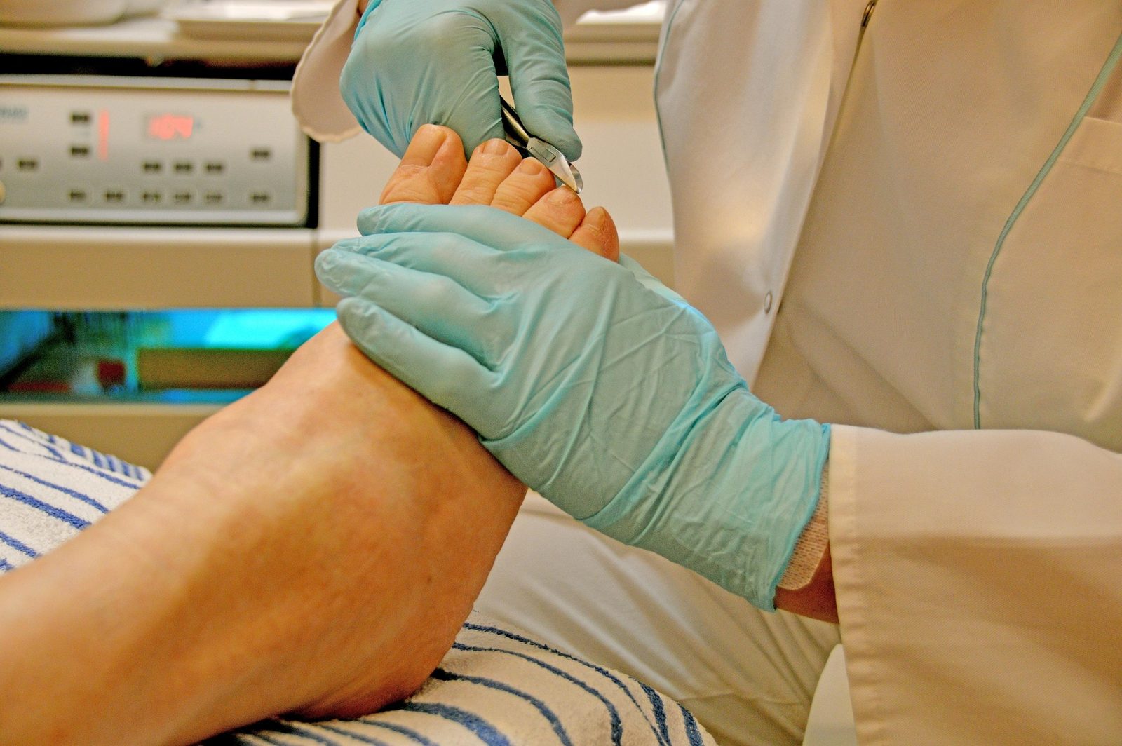 Une infirmière gantée qui soigne les orteils d’un patient